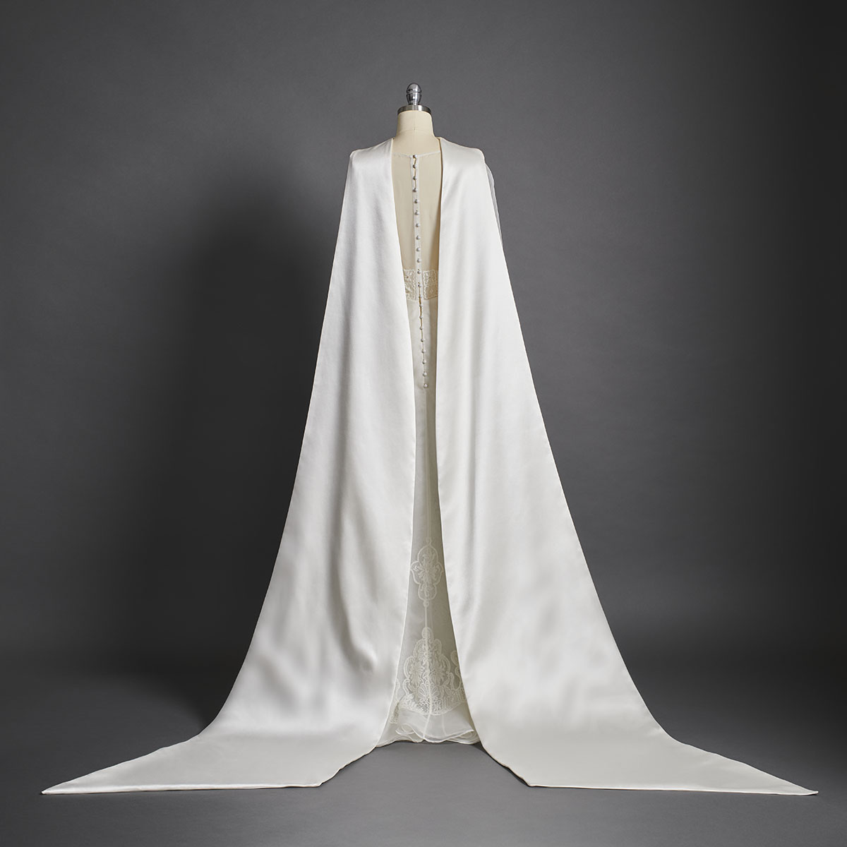 Composed of fine silk organza, this wedding dress is inspired by the light and enchantment of the magnificent crystal chandeliers that illuminate the Palais Garnier. Hand-stitched French lace has been used to create intricate motifs on the dress, while the long train is made of a heavy silk satin. - DELPHINE GENIN